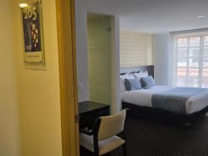 ボゴタにあるHotel Castellana 95 Bogota By Hoteles Confort 80のベッドと椅子と窓のある寝室