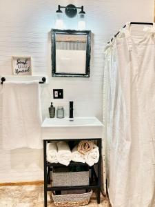 un baño con lavabo y espejo en Santa Fe Traincars Private and Luxurious in the Country, en Hutchinson