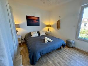 een slaapkamer met een groot bed met een blauwe deken bij T3 avec jardin privatif proche plage et commerces in Saint-Gilles-Croix-de-Vie +33 foto's