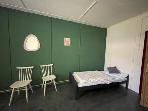 Zimmer mit einem Bett und zwei Stühlen in der Unterkunft Carlsbad Wellness & Camping Resort in Pirkenhammer + 34 Fotos