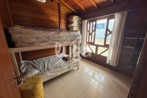 Casa Aconchegante – A 200m da praia da Pinheira في بينيرا: غرفة مع سرير بطابقين في غرفة مع نافذة