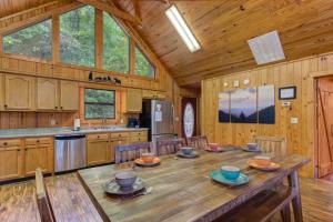 a large wooden kitchen with a wooden table and chairs at Sage Grass Retreat By Avada Properties in Line Spring