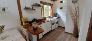 cocina con mesa de madera y fregadero en Delta Garden I, en San Carlos de Bariloche