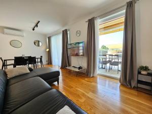 a living room with a couch and a table at TI Amo Holiday House - Heated Pool in Kaštela
