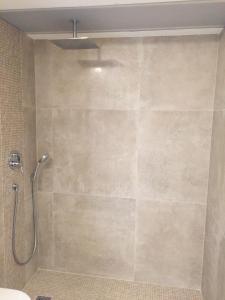 a shower in a bathroom with a tile wall at Villa Defendum in Vallauris +14 photos