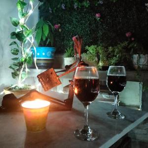 ChavarríaにあるCasa Cualliのワイン2杯、テーブルの上にキャンドル