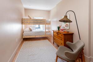 - une chambre avec des lits superposés, un bureau et une chaise dans l'établissement 4 Million Dollar Manhattan Brownstone Brand New, à New York