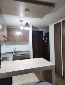 a kitchen with a table and a black refrigerator at Flor hospedaje in Buenos Aires