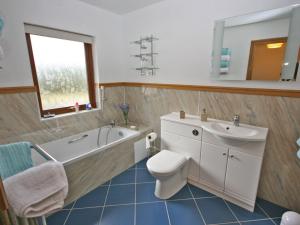 a bathroom with a tub and a toilet and a sink at Laggansally Lodge in Leswalt +19 photos
