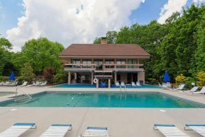 ein Haus mit einem Swimmingpool vor einem Gebäude in der Unterkunft Three Bears Lodge - Outdoor Hot Tub, Game Room, Pet Friendly + Chalet Village Resort Access in Chalet Village