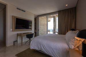 Un dormitorio con una cama, un televisor y un escritorio. en Stunning Sea Views from 3BR Penthouse F3, en Pendales