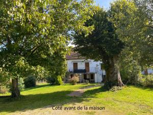 a white house with trees in the yard at La maison de Maxou in Briare