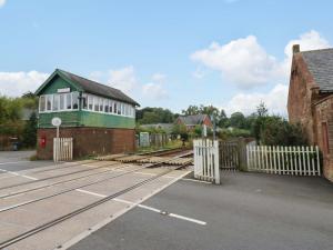 a train station with a gate and a building at Milford in Great Corby