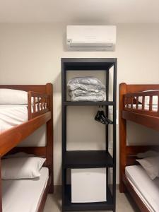 ウベルランジアにあるWEL Homeの二段ベッド2台、ファンが備わる客室です。