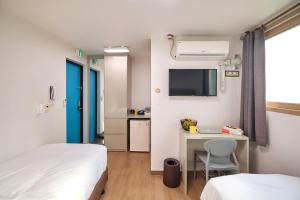 a room with two beds and a desk and a kitchen at Chason M Dongdaemun in Seoul