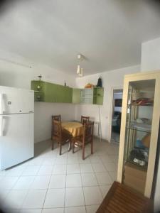 a kitchen with a table and a white refrigerator at Joujou Aprt in Monastir