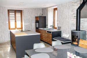 a kitchen with a stove and a table with chairs at Charmant Gîte avec sauna au cœur des Hautes Vosges in Ban-sur-Meurthe-Clefcy +22 photos