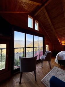 une chambre avec un lit et un balcon avec vue dans l'établissement İsgobya Dağ Evleri Sümela Manastırı, à Macka