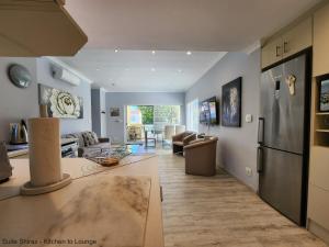eine Küche und ein Wohnzimmer mit einem Sofa und einem Kühlschrank in der Unterkunft Suite Shiraz in Meadowridge