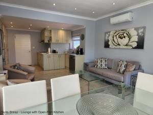 eine Küche und ein Wohnzimmer mit einem Glastisch in der Unterkunft Suite Shiraz in Meadowridge
