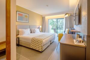 a hotel room with a bed and a window at Holiday Inn Algarve Albufeira by IHG in Albufeira