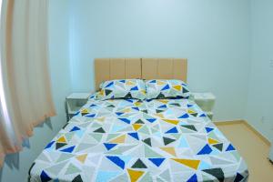 une chambre avec un lit avec une couette colorée dans l'établissement Conforto em Boa Vista com varanda e garagem privado, à Boa Vista