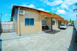 une maison avec une voiture garée à côté dans l'établissement Conforto em Boa Vista com varanda e garagem privado, à Boa Vista