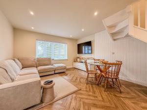 a living room with a couch and a table at Coastal Calm at Stanpit Hideaway in Christchurch