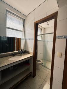 a bathroom with a sink and a toilet and a mirror at Poente Hostel in Belo Horizonte +27 photos