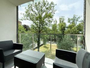 a balcony with a table and chairs and a large window at Romantica SPA Kraków in Kraków