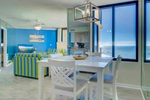 a kitchen and dining room with a white table and chairs at Beautiful Oceanfront Condo in Panama City Beach