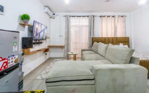 a living room with a couch and a tv at Terry's Haven with AC in Mombasa