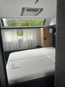 a bedroom with a bed in the back of a van at Beautiful, luxurious Caravane property in Rothrist