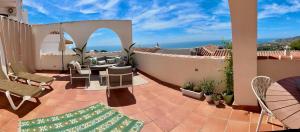 taras z krzesłami i stołami na balkonie w obiekcie Casa Paz - 2 bedroom - Terrace VIEWS & hot tub w mieście Nerja
