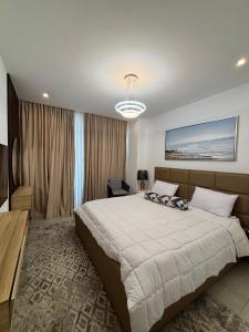a bedroom with a large bed and a chandelier at Real Homes 2 bedroom Nova Apartments in Accra