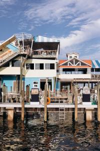 a large house on the water next to a dock at Harbor Suites at Harborwalk Village in Destin