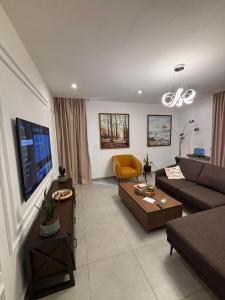 a living room with a couch and a tv at Real Homes 2 bedroom Nova Apartments in Accra +15 photos