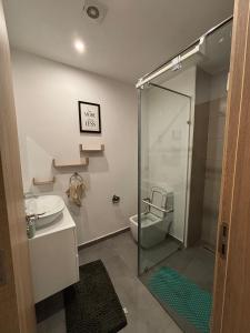 a bathroom with a shower and a toilet and a sink at Real Homes 2 bedroom Nova Apartments in Accra +15 photos