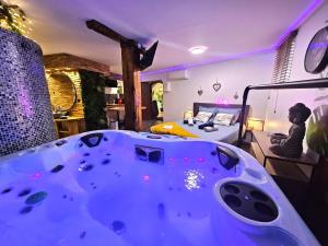 a large bath tub in a room with a bed at Le refuge de Bergheim - Proche Colmar - Sur la route des Vins - Studio de luxe avec Jacuzzi Privatif in Bergheim