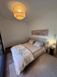 a bedroom with a large bed with a light at Stylish 2BR Monaco Border Flat, Terrace & Parking in Beausoleil