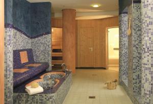 a bathroom with a tub with a sink and a couch at NH Berlin Alexanderplatz in Berlin +54 photos