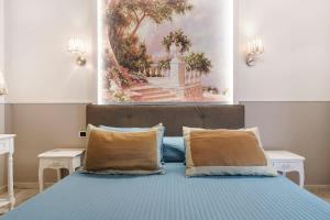 a bedroom with a blue bed with two pillows at Beatrice King Suite Room in Florence