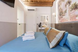 a bedroom with a bed with blue sheets and pillows at Beatrice King Suite Room in Florence