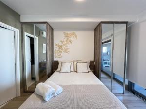 a bedroom with a large bed with glass walls at Acrópole Studio - Vaga, Wifi e Piscina no Brooklin in Sao Paulo