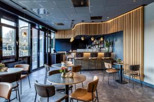 a restaurant with tables and chairs and a bar at NH Noordwijk Conference Centre Leeuwenhorst in Noordwijkerhout +66 photos