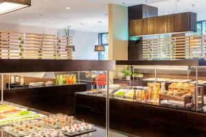 a restaurant kitchen with a lot of food on display at NH Stuttgart Airport in Filderstadt +37 photos