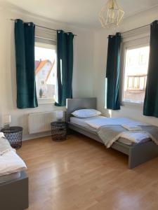 1 Schlafzimmer mit 2 Betten und grünen Vorhängen in der Unterkunft Work & Sleep Schwäbisch Gmünd in Schwäbisch Gmünd