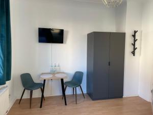 ein Esszimmer mit einem Tisch, 2 Stühlen und einem Schrank in der Unterkunft Work & Sleep Schwäbisch Gmünd in Schwäbisch Gmünd