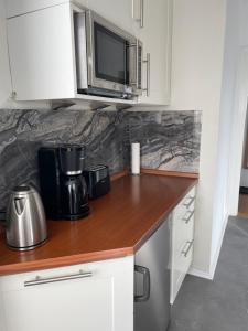 eine Küche mit einer Theke, einer Kaffeemaschine und einer Mikrowelle in der Unterkunft Work & Sleep Schwäbisch Gmünd in Schwäbisch Gmünd + 7 Fotos