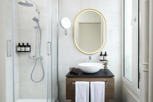 a bathroom with a sink and a mirror at NH Paris Opéra Faubourg in Paris